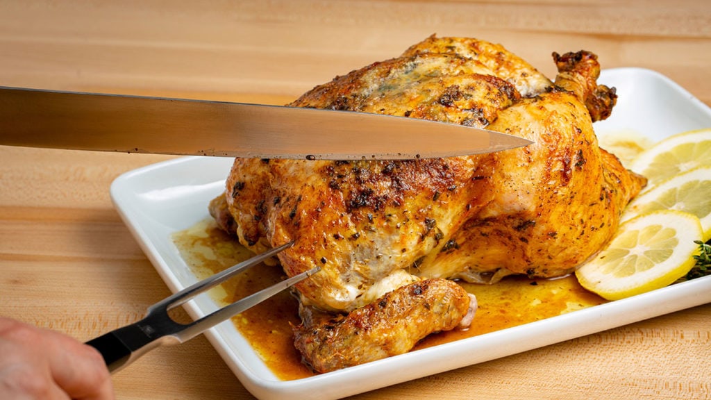 cutting up a whole roasted chicken